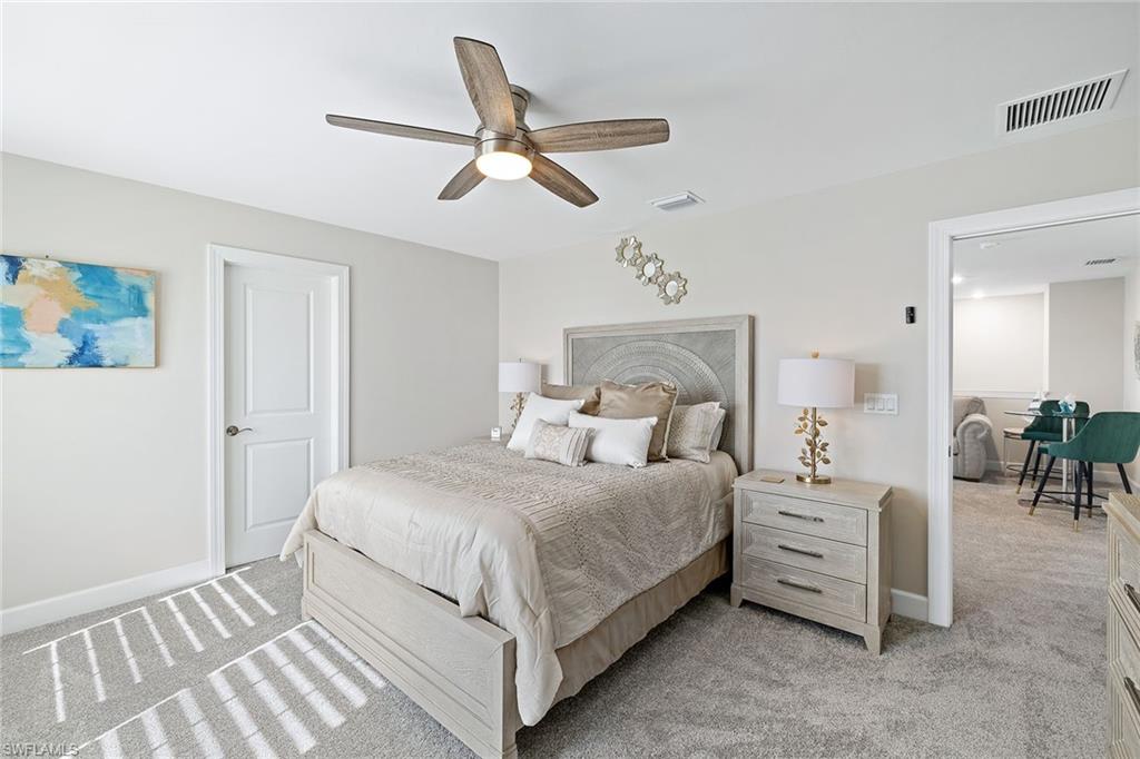 1973 Yellowfin Circle Naples, FL 34114 - Photo 30 of 44 a bedroom with a bed and a chandelier