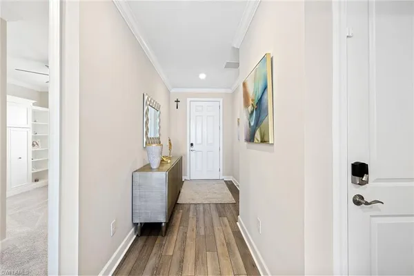 a view of a hallway with wooden floor and staircase