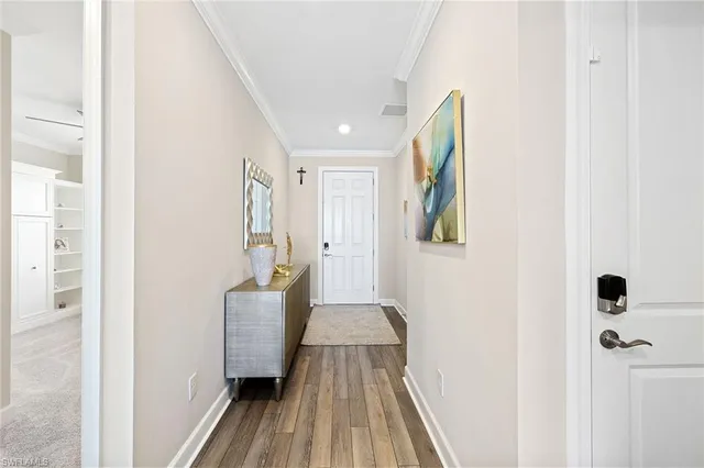 a view of a hallway with wooden floor and staircase