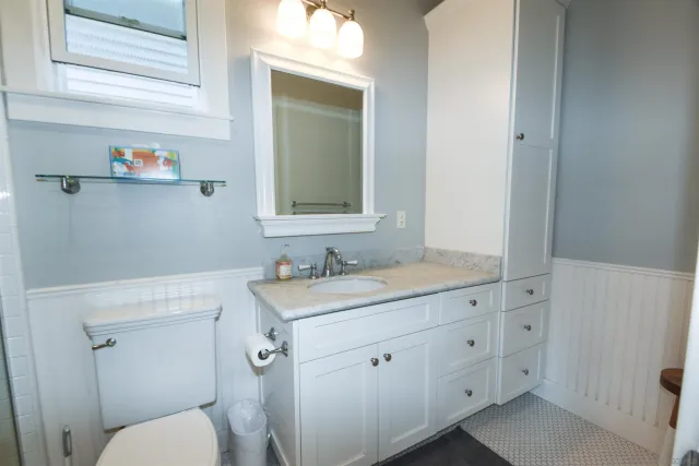 a bathroom with a toilet sink and mirror