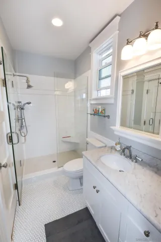 a bathroom with a granite countertop sink toilet and shower