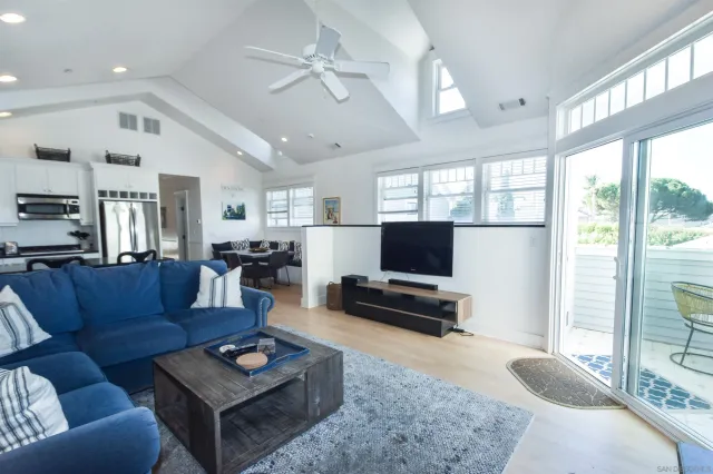 a living room with furniture a flat screen tv and a large window