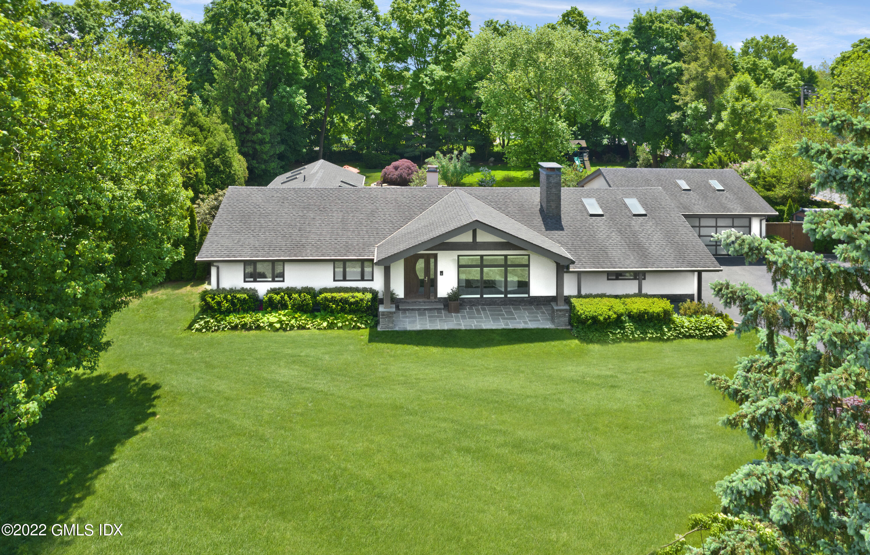 a aerial view of a house next to a big yard and large trees