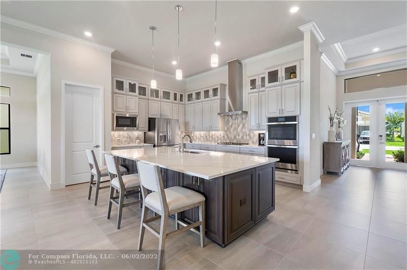 a kitchen with kitchen island granite countertop a table and chairs in it