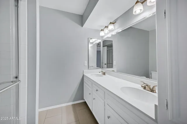 a spacious bathroom with a double vanity sink and a mirror