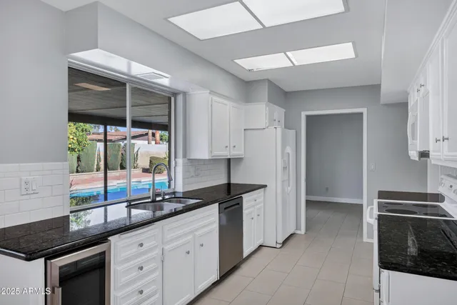 a kitchen with granite countertop a sink stainless steel appliances and cabinets