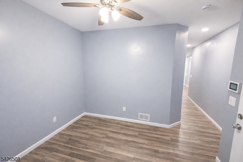 411 South 16th Street, Unit 1 Newark, NJ 07103 - Photo 3 of 39 an empty room with wooden floor and staircase
