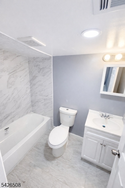 411 South 16th Street, Unit 1 Newark, NJ 07103 - Photo 36 of 39 a white toilet sitting next to a bathroom sink and tub