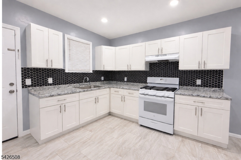 411 South 16th Street, Unit 1 Newark, NJ 07103 - Photo 4 of 39 a kitchen with granite countertop white cabinets and white appliances
