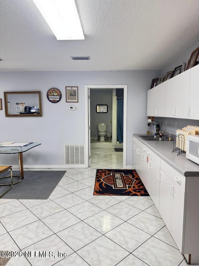 8540 West Beaver Street Jacksonville, FL 32220 - Photo 14 of 18 a kitchen with a sink a stove and cabinets