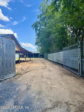 a view of a yard with wooden fence