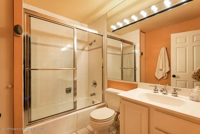 a bathroom with a shower sink vanity mirror and toilet