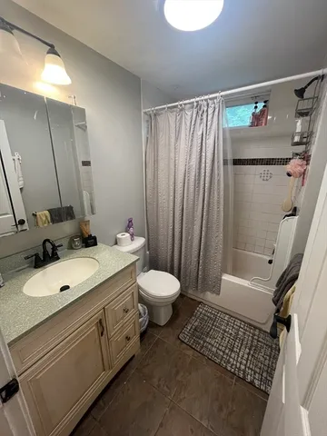 a bathroom with a granite countertop sink toilet and shower
