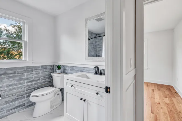 a bathroom with a toilet sink and mirror