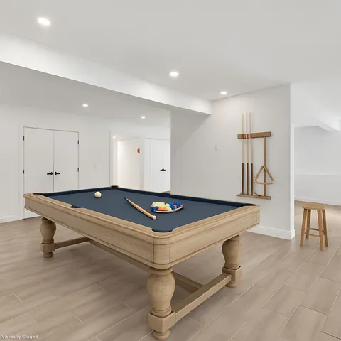 a room with wooden floor pool table and furniture