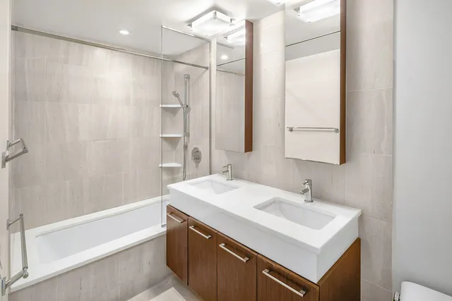 a bathroom with a sink mirror vanity and a bathtub
