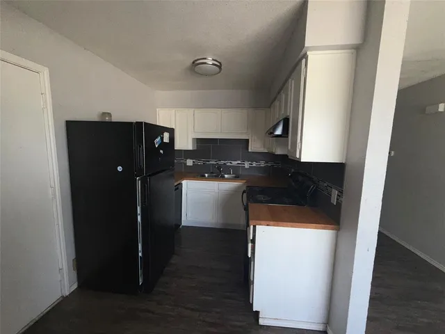 a kitchen with a refrigerator and cabinets