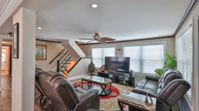 a living room with furniture a flat screen tv and a window