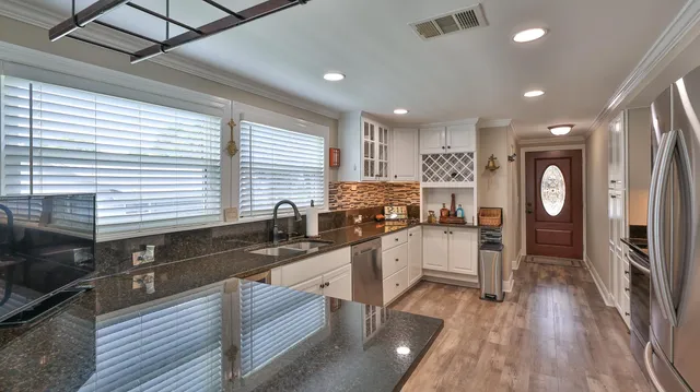 a kitchen with stainless steel appliances granite countertop a refrigerator sink and stove