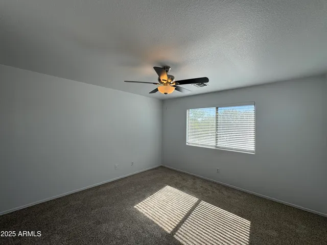 an empty room with windows and fan