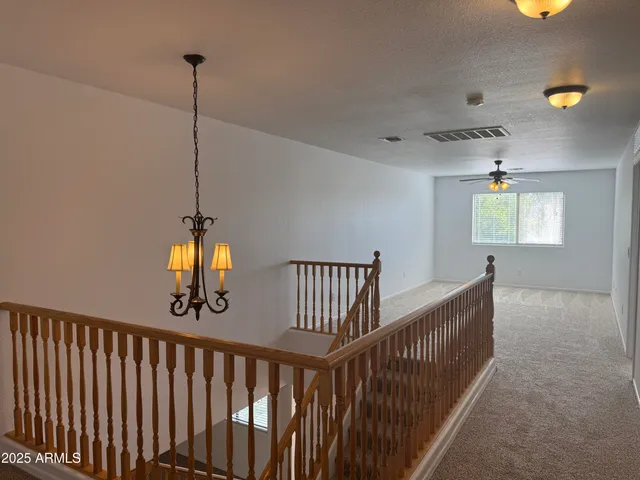 a view of a hallway with window and chandelier