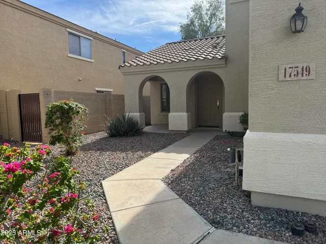 a front view of a house with plants
