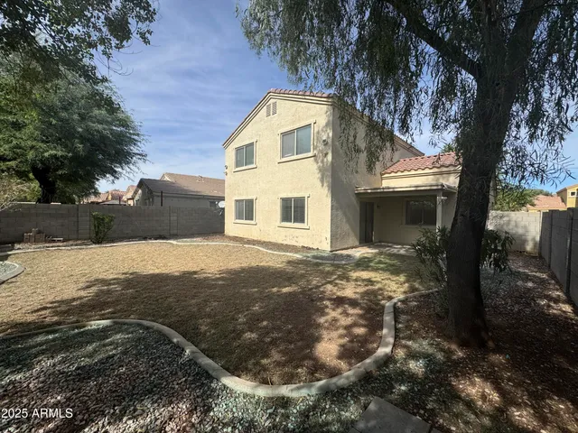 a view of a yard in front of a house with large trees