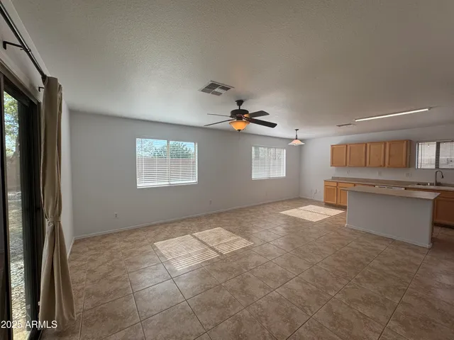 a view of a kitchen an empty room and windows