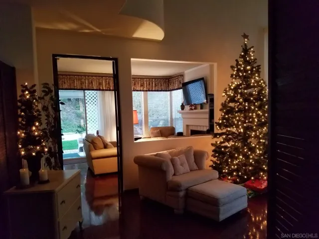 a living room with furniture flowers and a large window