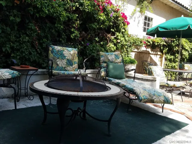 a view of a backyard with table and chairs and potted plants