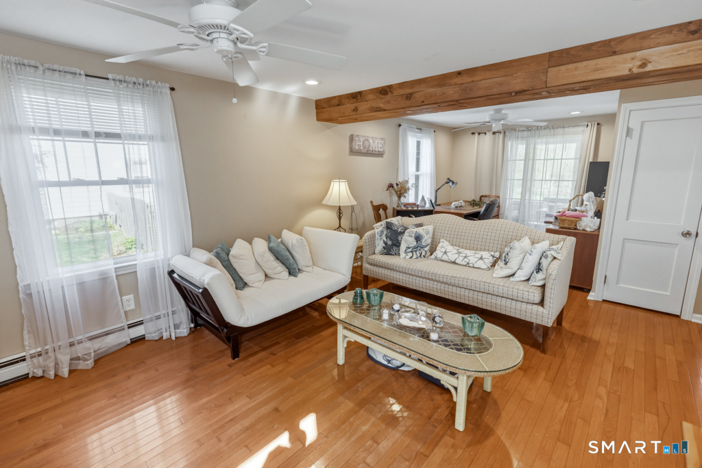 49 River Street Old Saybrook, CT 06475 - Photo 12 of 28 a living room with furniture a wooden floor and a window