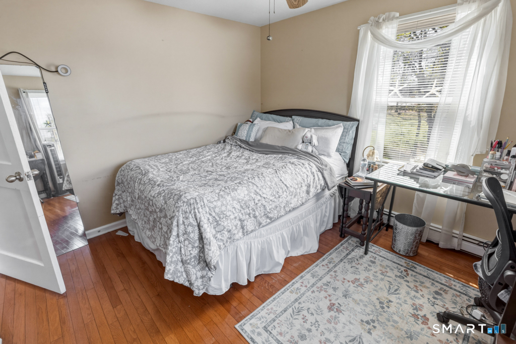 49 River Street Old Saybrook, CT 06475 - Photo 18 of 28 a bedroom with a bed and wooden floor
