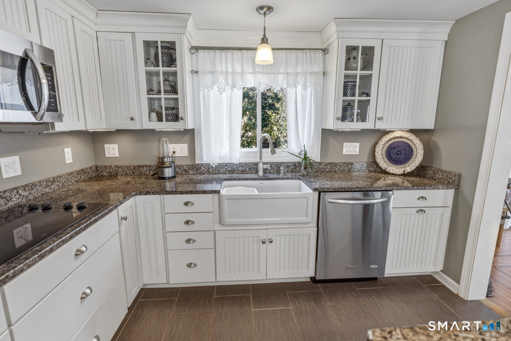 49 River Street Old Saybrook, CT 06475 - Photo 6 of 28 a kitchen with stainless steel appliances granite countertop a sink a stove a microwave and cabinets