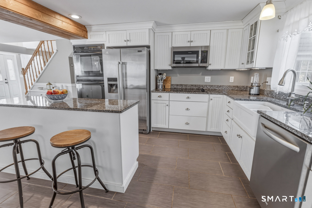 49 River Street Old Saybrook, CT 06475 - Photo 7 of 28 a kitchen with stainless steel appliances granite countertop a stove a sink and a refrigerator