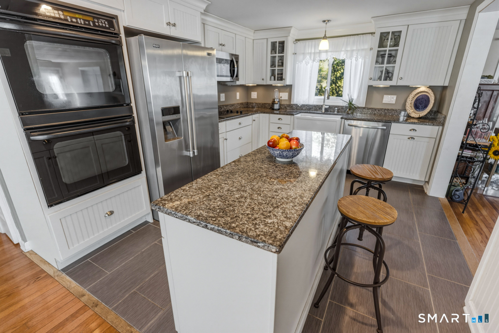 49 River Street Old Saybrook, CT 06475 - Photo 8 of 28 a kitchen with refrigerator and chairs