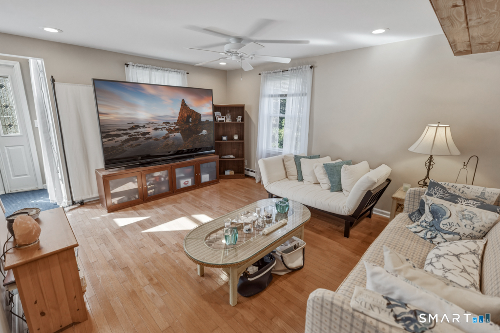 49 River Street Old Saybrook, CT 06475 - Photo 10 of 28 a living room with furniture and a flat screen tv