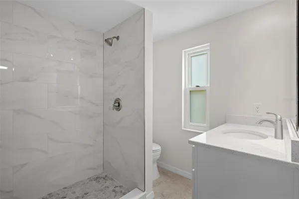 a bathroom with a sink a toilet and shower