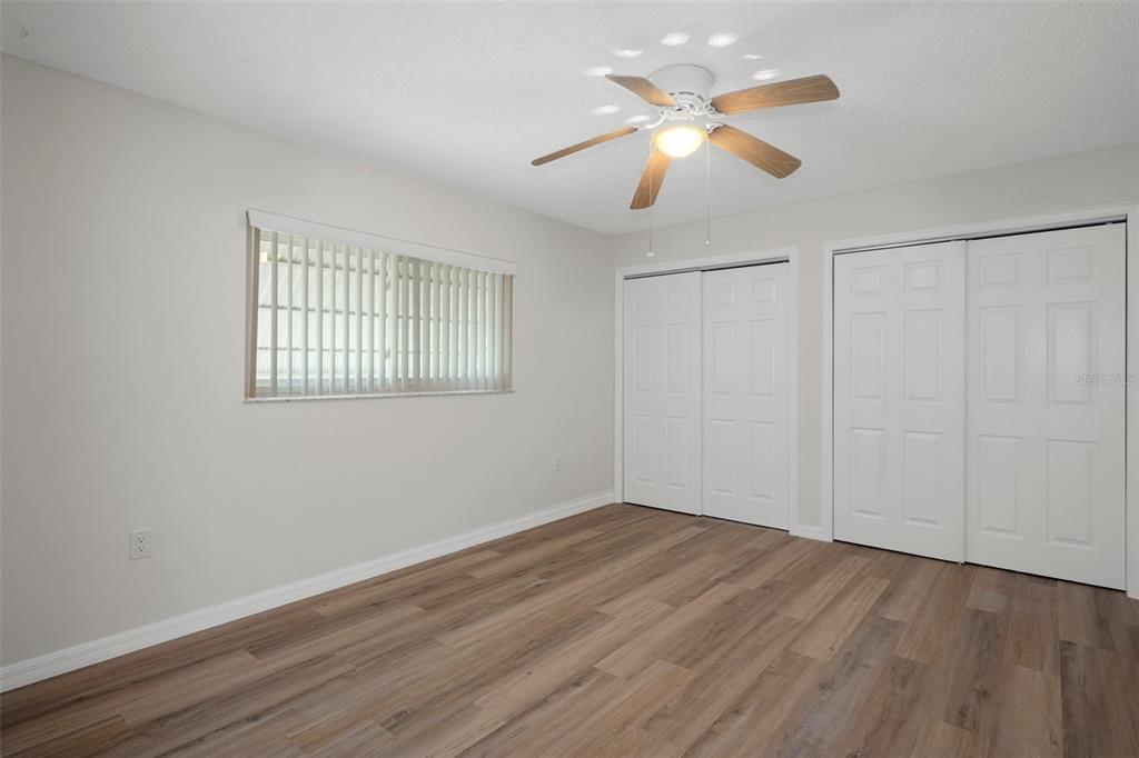 4315 Flexer Drive Hernando Beach, FL 34607 - Photo 35 of 48 an empty room with wooden floor chandelier fan and windows