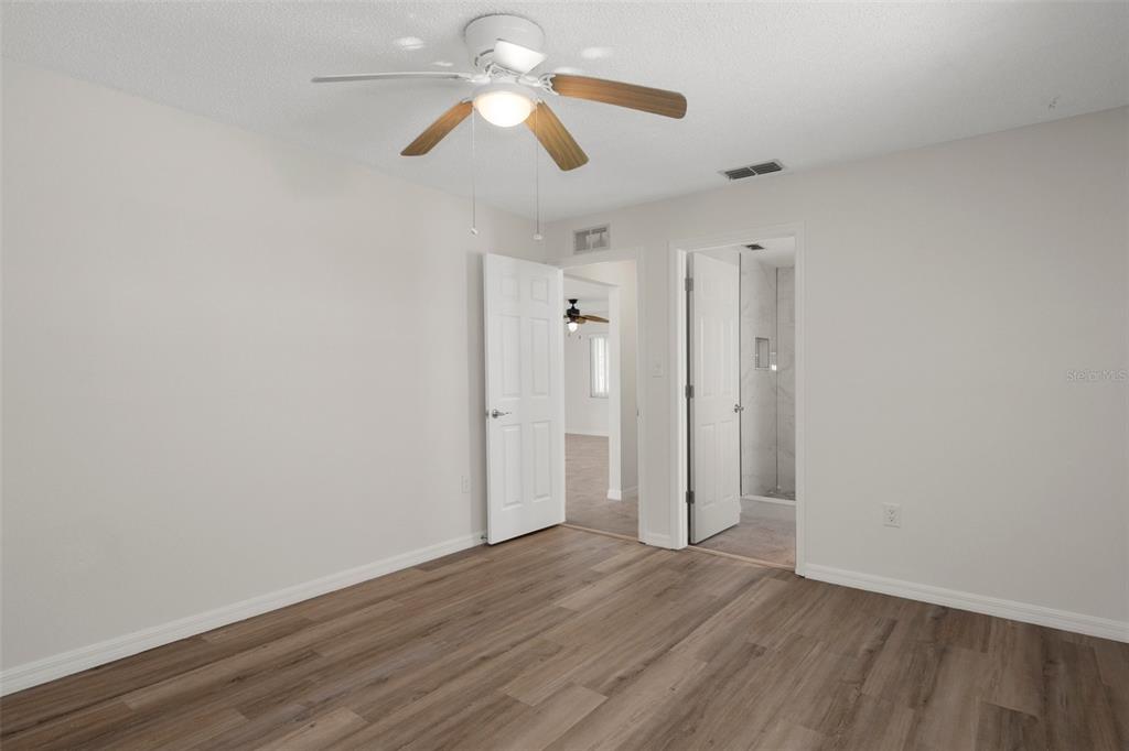 4315 Flexer Drive Hernando Beach, FL 34607 - Photo 36 of 48 an empty room with wooden floor ceiling fan and window