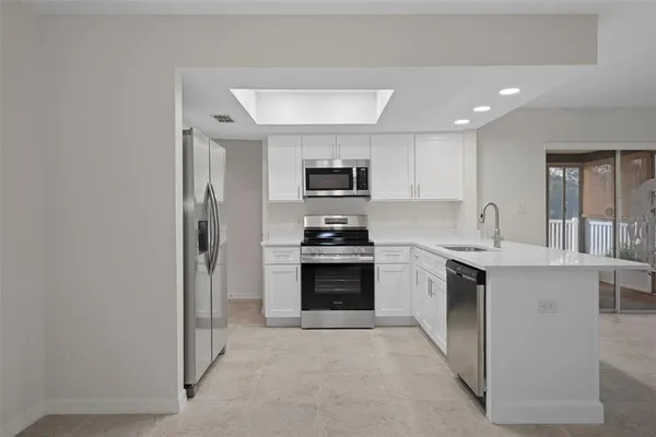 a kitchen with a stove top oven and refrigerator