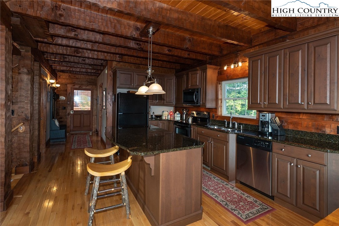 298 Granny's Ridge Road Ferguson, NC 28624 - Photo 3 of 18 a kitchen with a table chairs and wooden cabinets