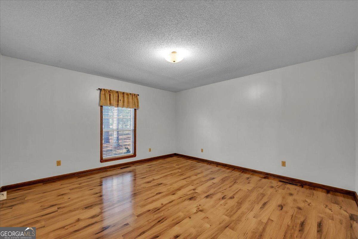 6501 Harley Trail Blackshear, GA 31516 - Photo 26 of 69 a view of an empty room with wooden floor and a window