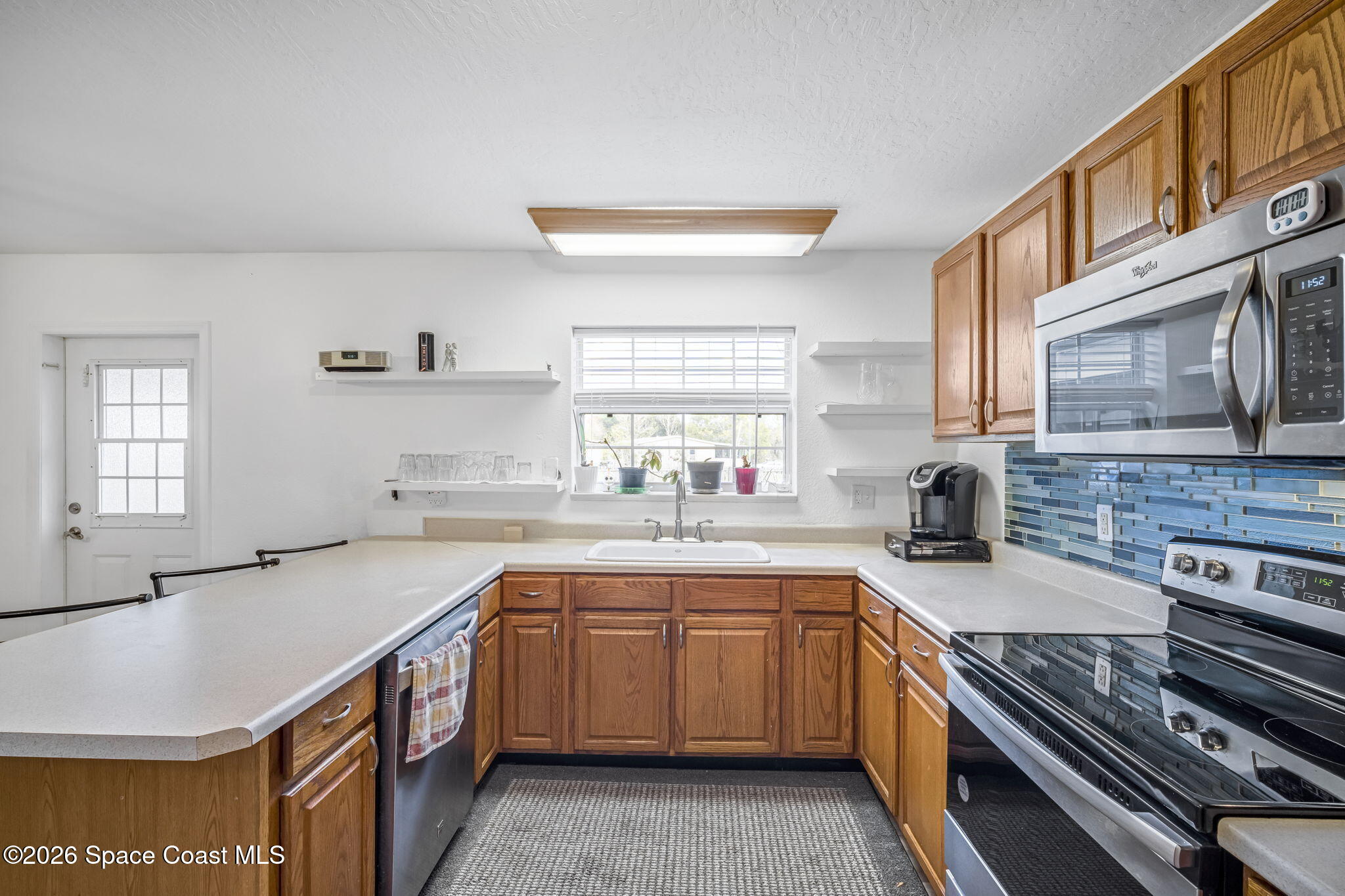 3404 Kilbee Street Mims, FL 32754 - Photo 9 of 30 a kitchen with a sink stove top oven and microwave