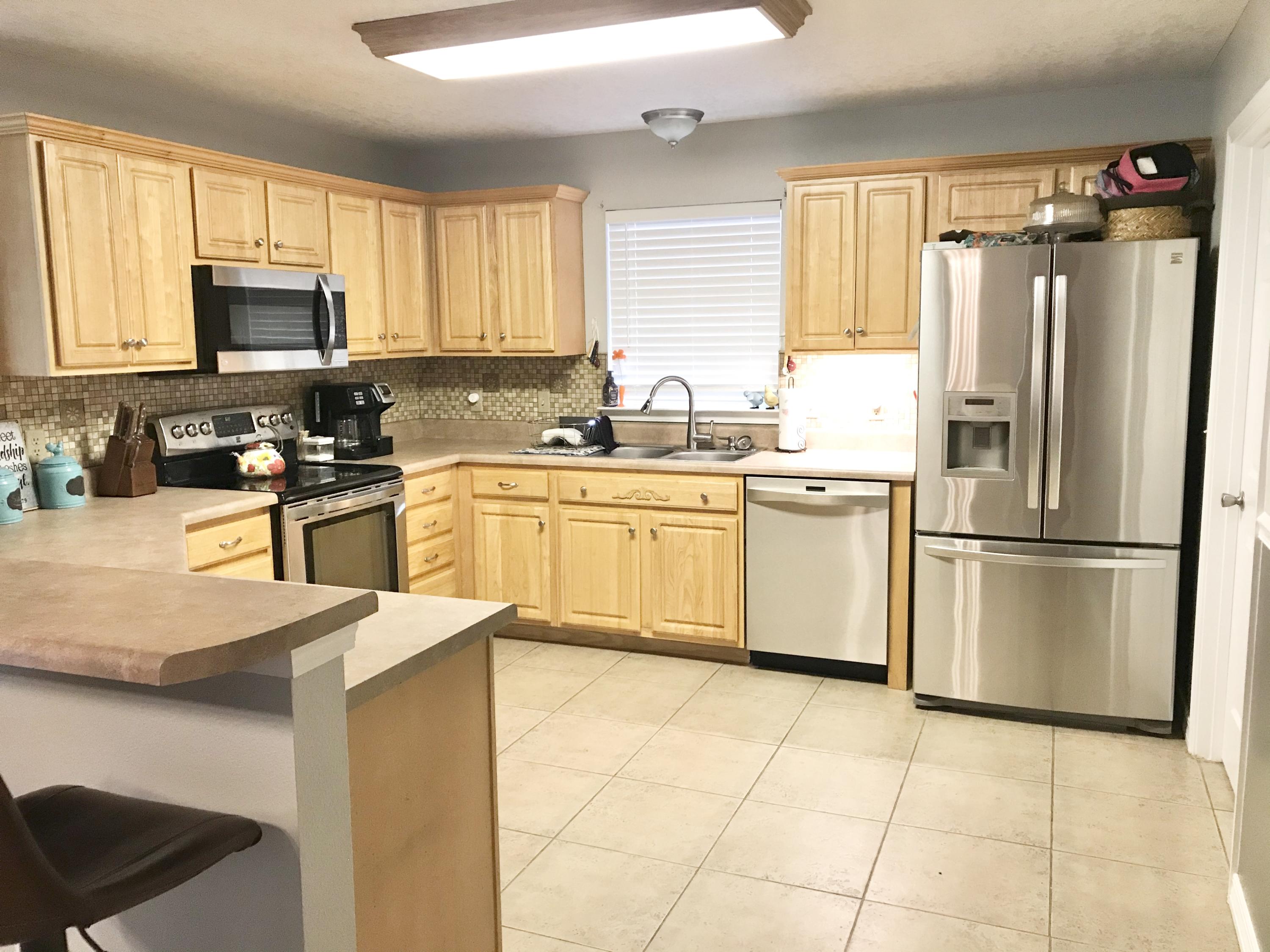 6593 Old River Road Baker, FL 32531 - Photo 15 of 23 a kitchen with stainless steel appliances granite countertop a refrigerator sink stove microwave and cabinets