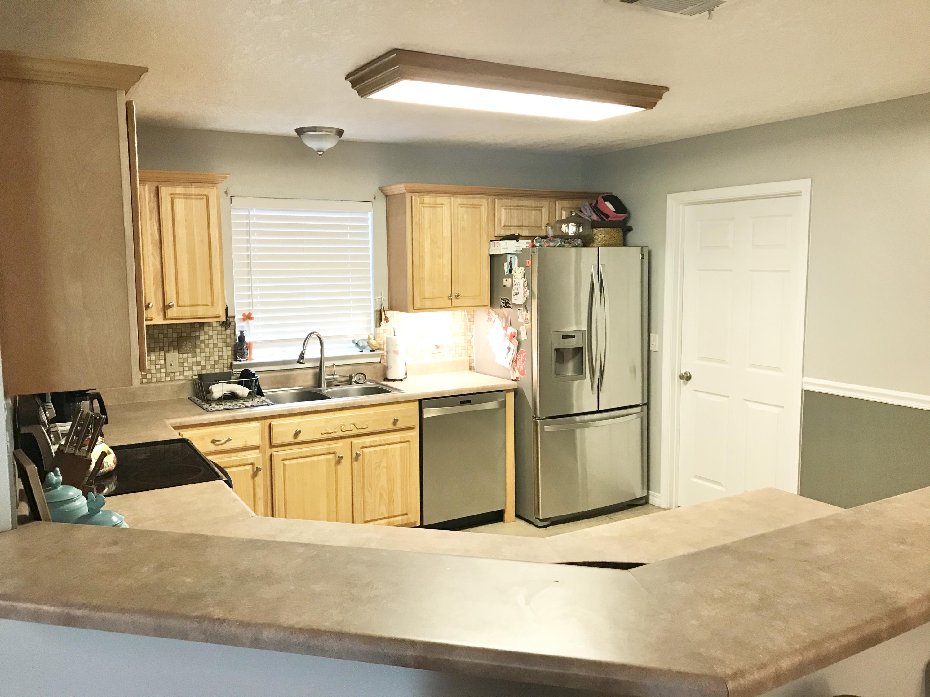 6593 Old River Road Baker, FL 32531 - Photo 16 of 23 a kitchen with a refrigerator a sink a stove and cabinets