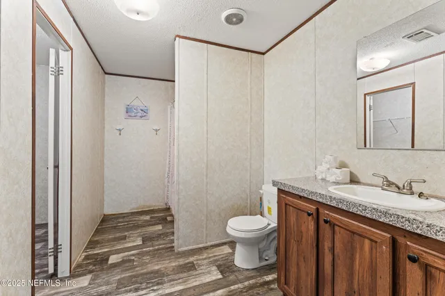a bathroom with a granite countertop sink toilet and shower