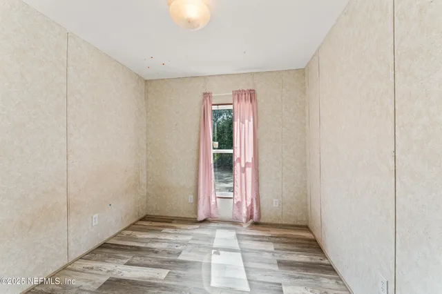a view of a room with wooden floor and windows