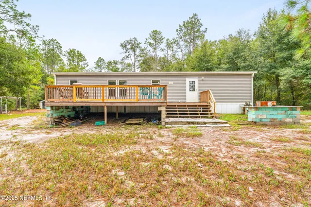 a view of a house with a backyard and trees