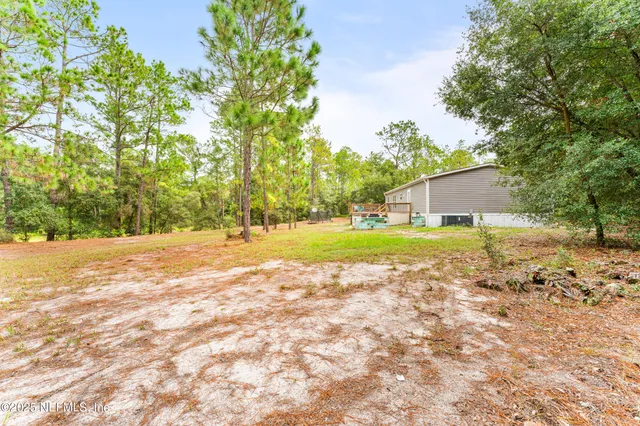 a view of a house with yard and basketball court