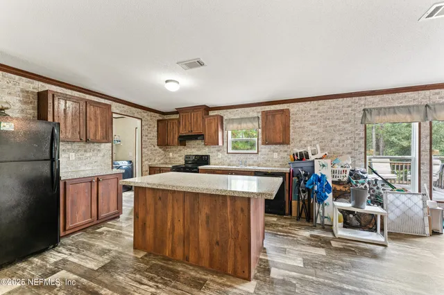 a kitchen with a stove a refrigerator and wooden floor